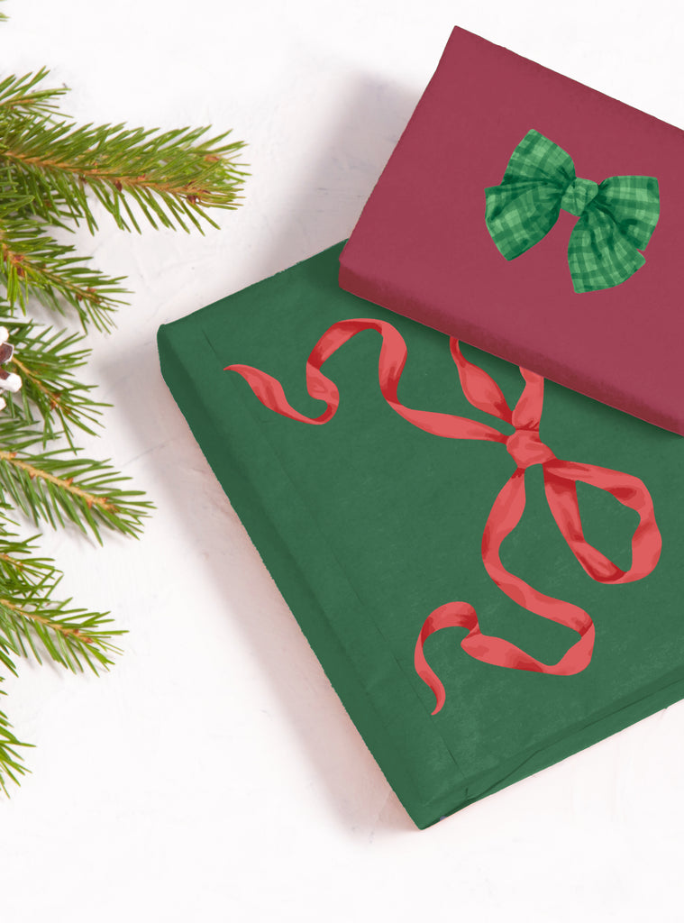 Two wrapped presents with green and red holiday ribbons stickers creating festive gift designs beside pine branches