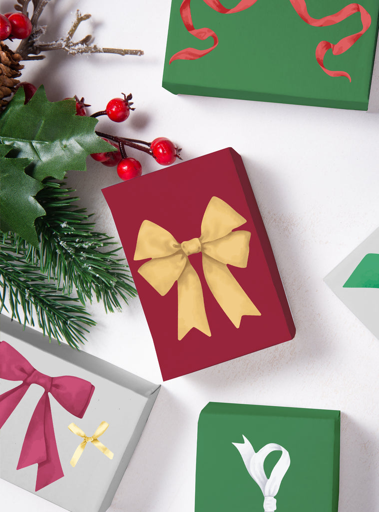 Holiday Ribbons Stickers applied on colorful wrapped gifts with festive greenery and red berries for seasonal decoration.