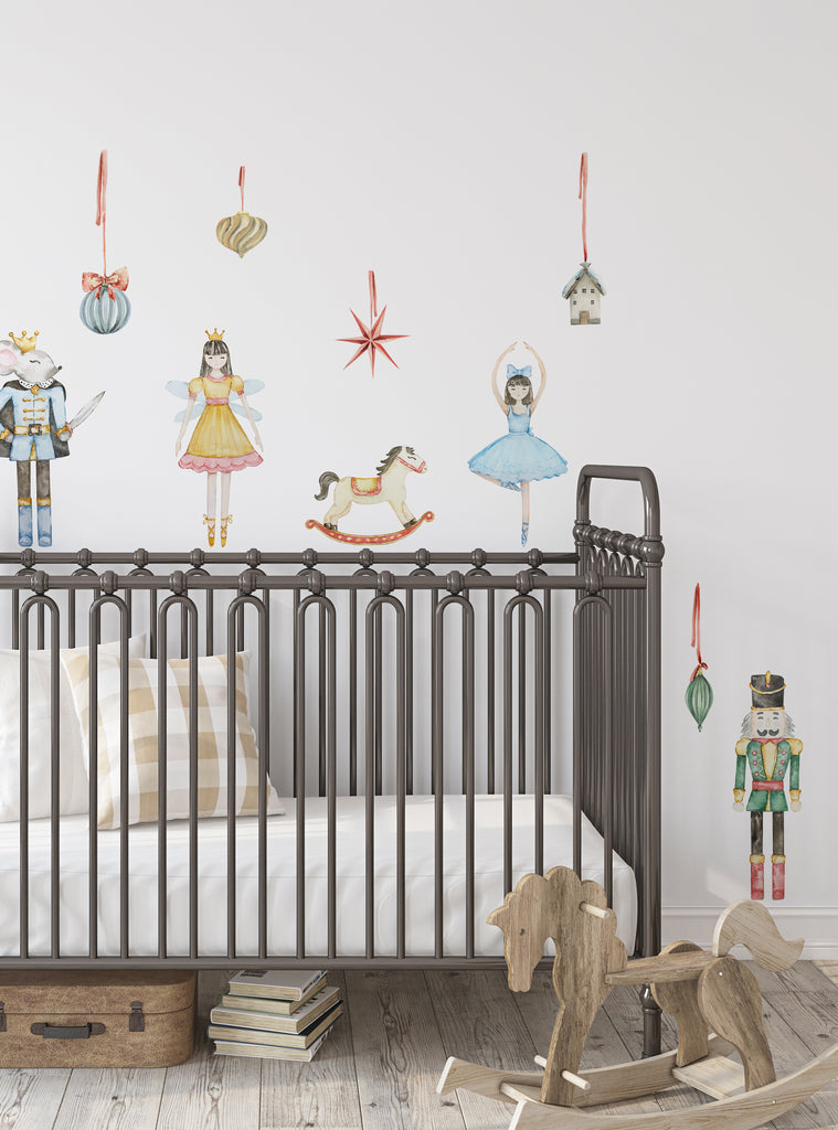 Nutcracker wall stickers featuring ballet characters, ornaments, and holiday-themed decorations above a crib in a nursery room.