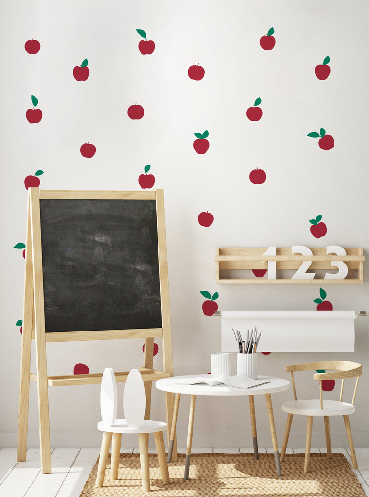 Bright classroom wall decorated with bright red apple fruit wall decals and green leaves in a playful kids' learning space