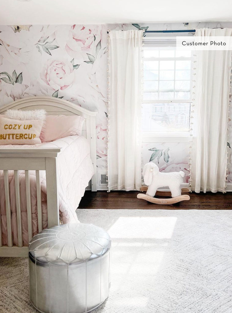Bright and airy nursery featuring Peony Flower Mural wallpaper with soft pink and green tones, cozy bed, and rocking horse toy.