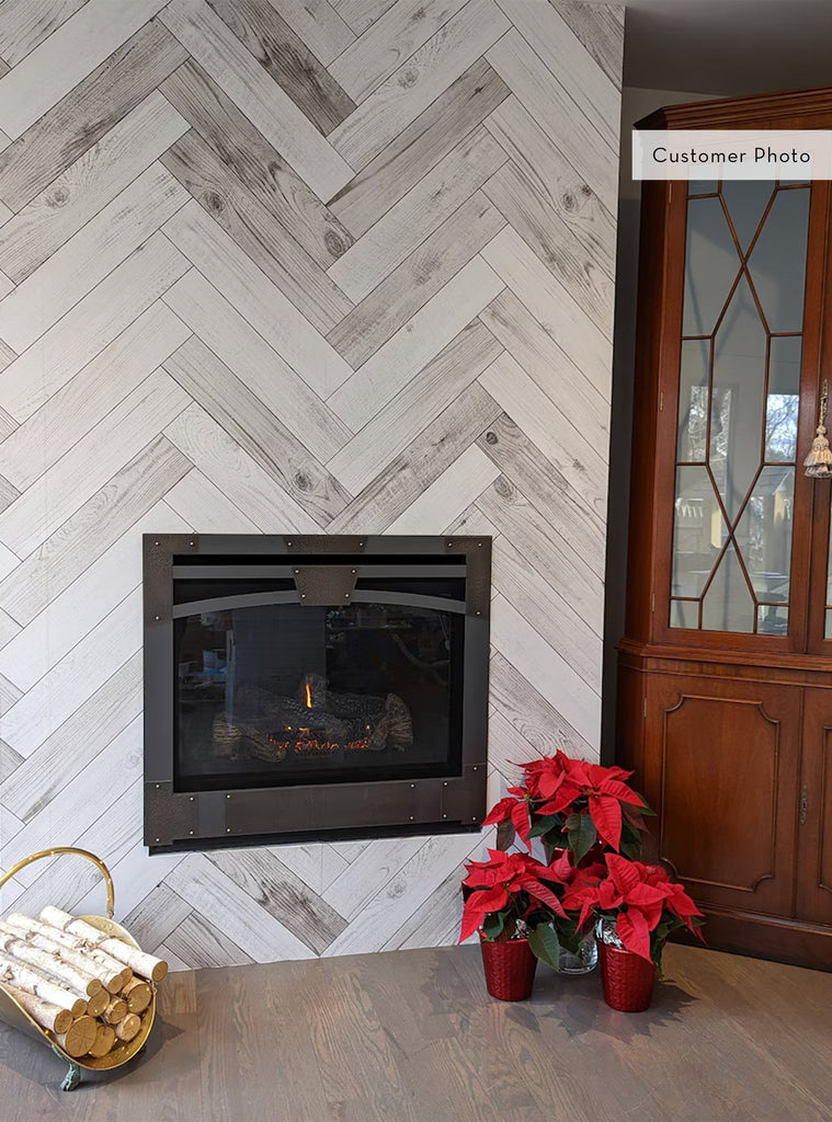 Cozy living room corner with herringbone whitewashed barn wood planks mural wallpaper and modern fireplace surrounded by plants and wood decor