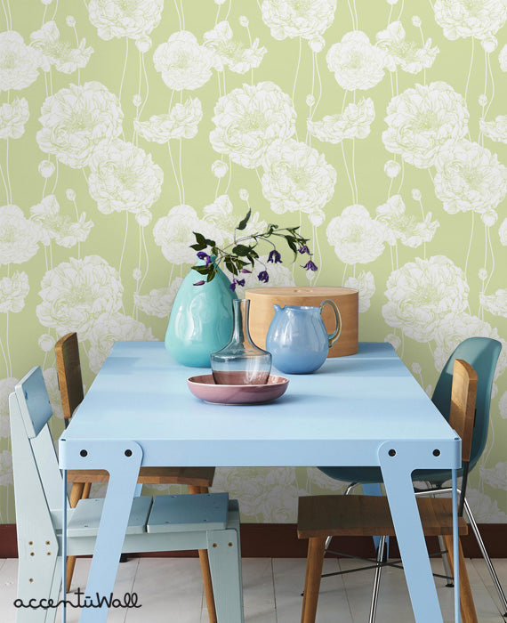 Light green peony wallpaper with white floral pattern behind a modern blue dining table set with vases and chairs in a cozy room