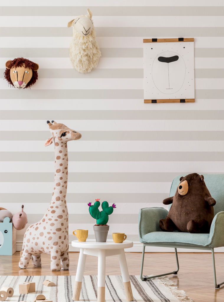 Kids nursery featuring horizontal stripes wallpaper in soft beige tones with playful animal decor and cozy furniture elements