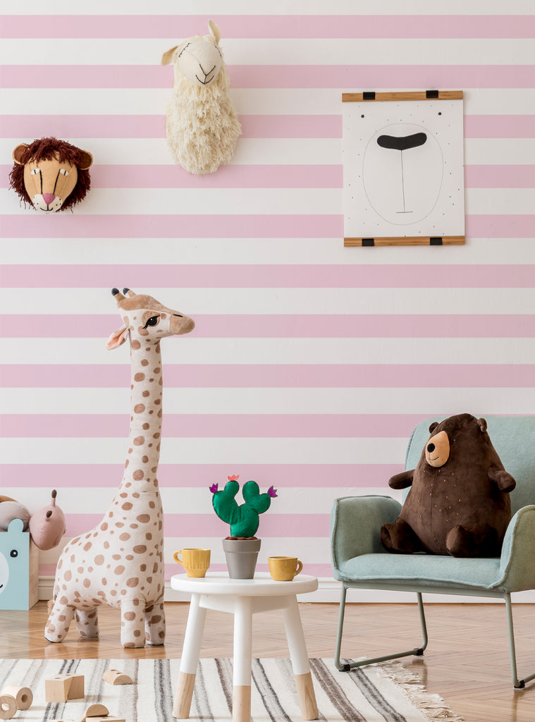 Playful kids nursery featuring pink and white horizontal stripes wallpaper with soft toys and cozy decor elements.