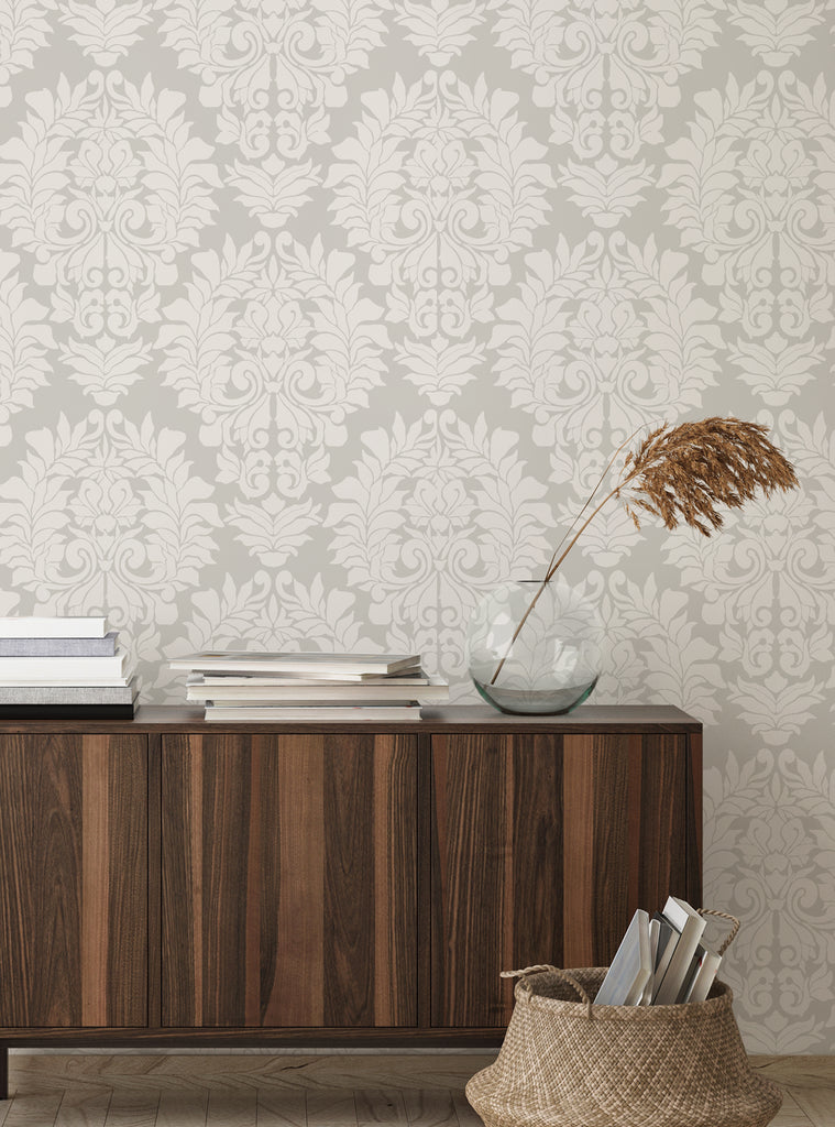 Neutral beige damask classic peel and stick wallpaper in a cozy room with wooden furniture and decorative accents