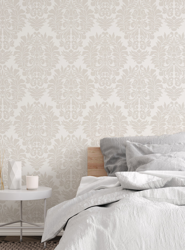 Elegant damask classic white peel and stick wallpaper in a cozy bedroom setting with soft gray and white bedding and bedside table decor.