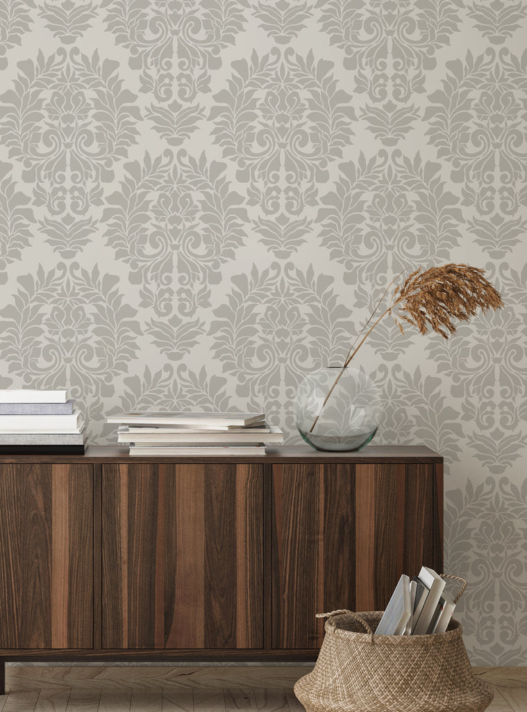 Elegant Damask Classic peel and stick wallpaper in beige with a wooden cabinet, basket, and decorative dried plant in a stylish room setup