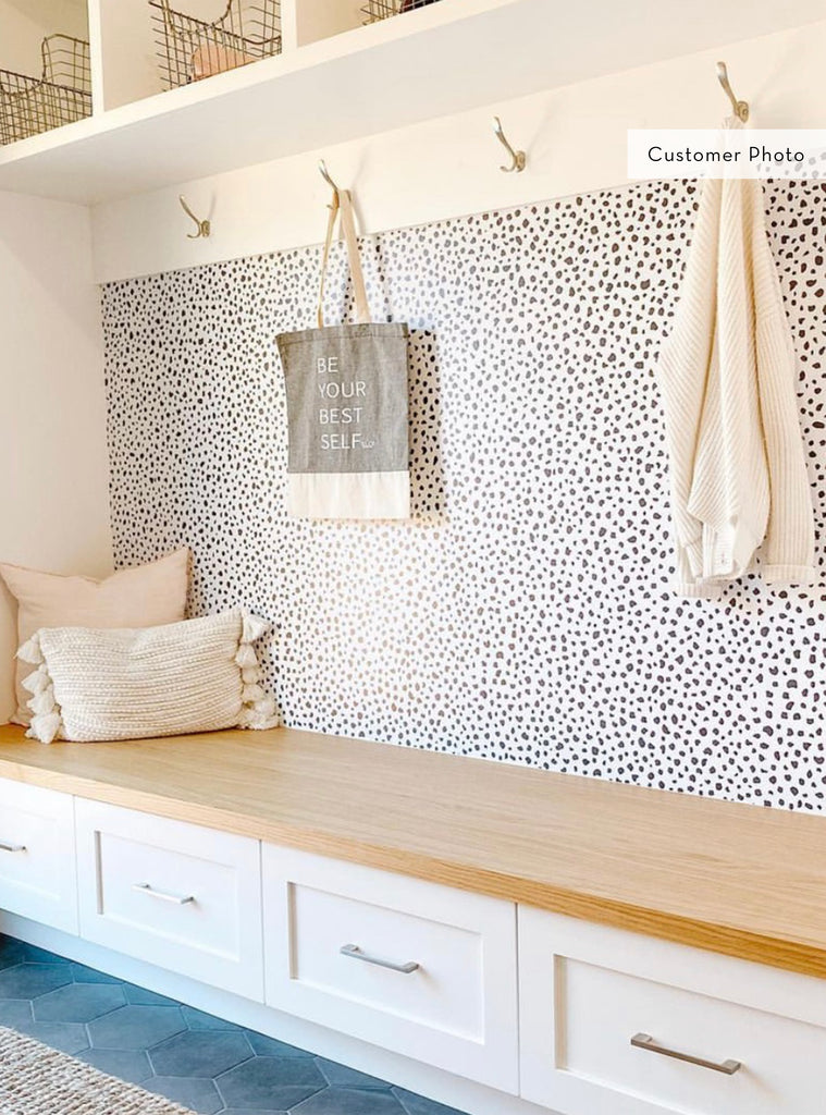 Cozy entryway with Speckle wallpaper adding a subtle pattern behind a wooden bench and white storage drawers in a modern home setting