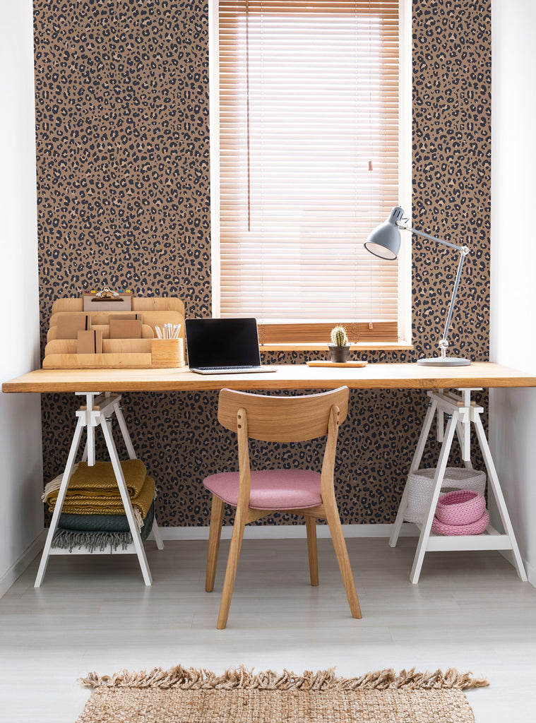 Modern workspace with simple shapes leopard wallpaper, wooden desk, chair with pink cushion, and natural light window blinds