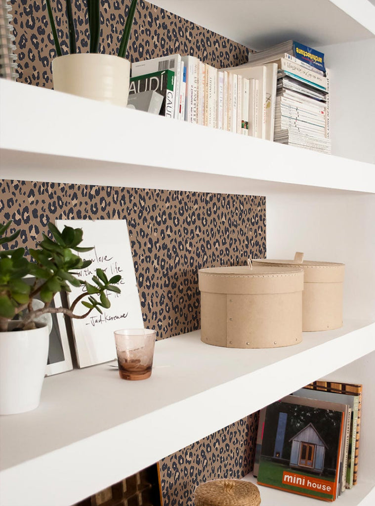 White shelving units decorated with plants, books, and beige storage boxes against leopard print wallpaper background