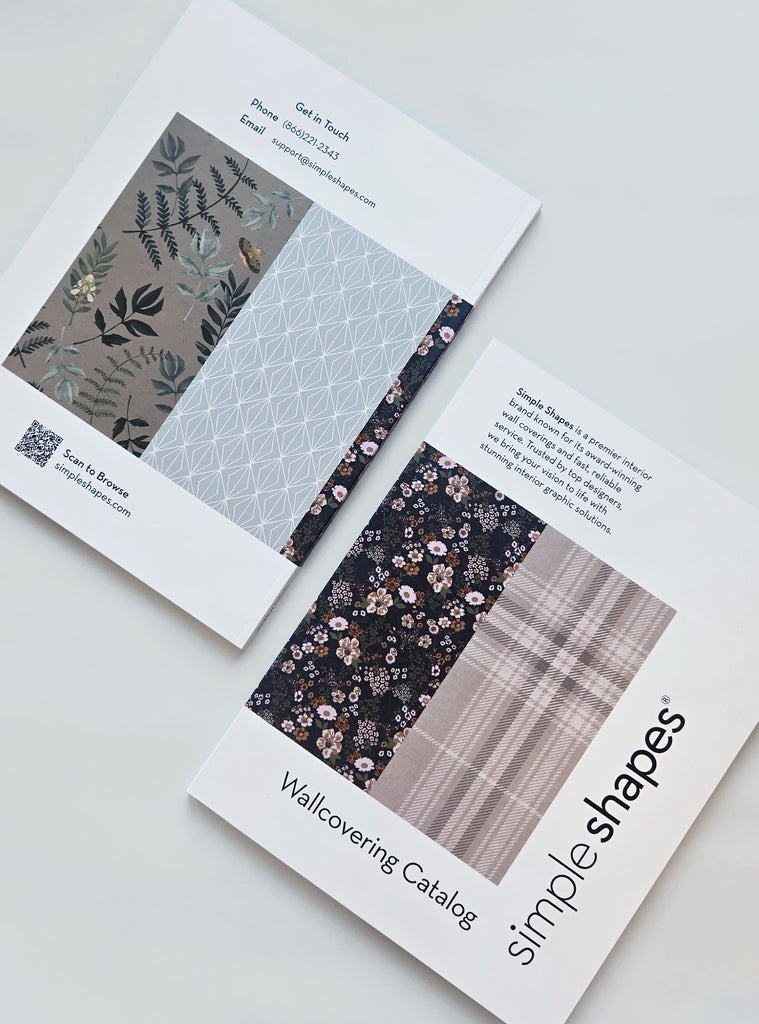 Open Simple Shapes wallcovering catalog displaying floral, geometric, and plaid wallpaper patterns with contact info and QR code visible