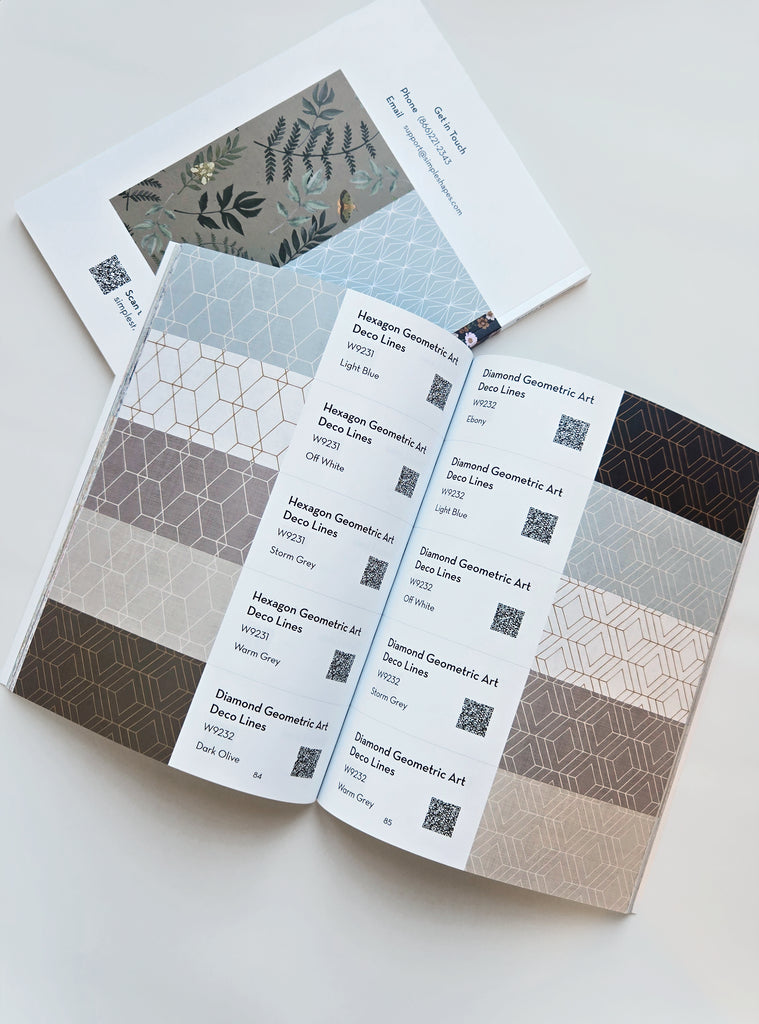 Open catalog featuring Simple Shapes wallcovering samples in geometric hexagon and diamond patterns with various neutral tones displayed