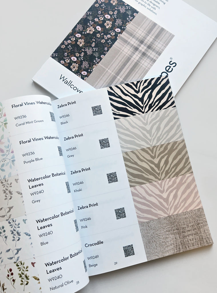 Open Simple Shapes Wallcovering Catalog showing floral, zebra print, and crocodile wallpaper samples in muted colors and patterns
