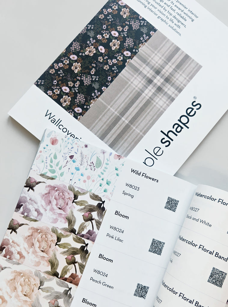 Open Simple Shapes wallcovering catalog showing floral and plaid wallpaper patterns with product details and QR codes for easy previewing