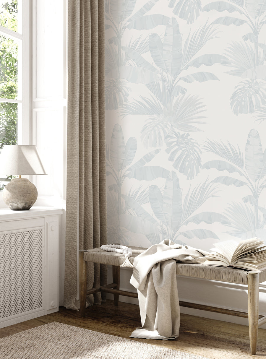 Cozy corner with nature wallpaper featuring subtle tropical leaves in soft blue and beige tones from the Featured Collection.
