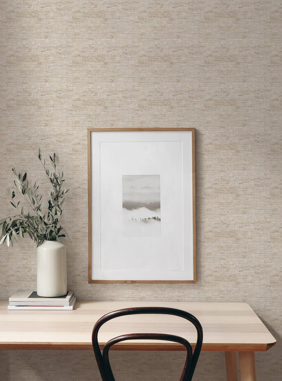 Cozy workspace with beige textured wallpaper from the Beige Wallpaper collection, featuring simple framed art and a plant in a ceramic vase.