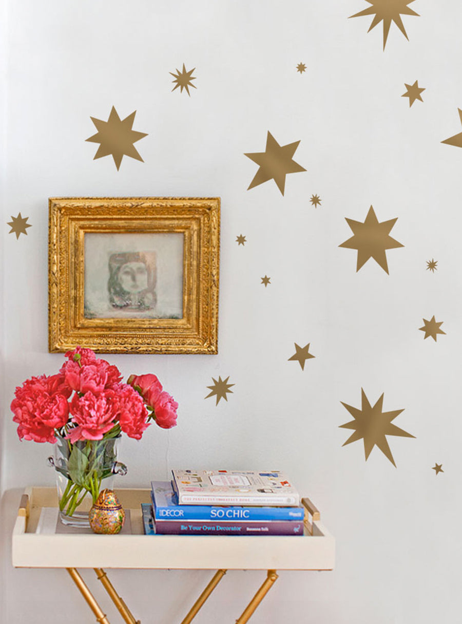Whimsical gold star wall decals grace the space, adding a touch of celestial charm to the cozy nursery or playroom. These eye-catching vinyl decals in metallic gold tones are perfect for creating a dreamy, starry atmosphere, sure to delight young imaginations. , Top Sellers,Wall Decals,Baby Nursery and Kids Wall Decals,All Products