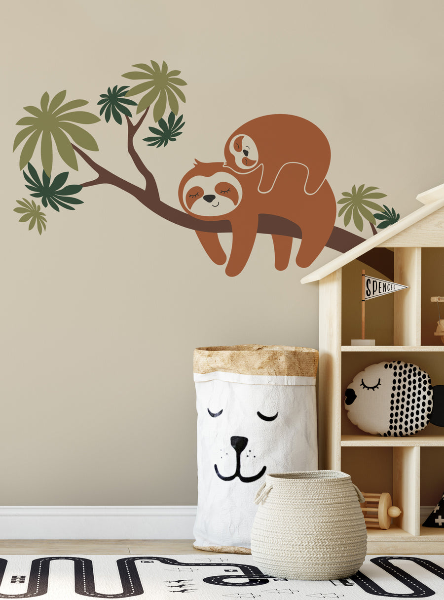 Sloths climbing on a lush tree branch with tropical leaves, creating a whimsical and soothing scene for a nursery or kid's room decor. This wall decal is a perfect addition to any Shopify product lineup featuring animal-themed, nature-inspired designs. Top Sellers, Wall Decals, Animal Decals, Tree Decals, Baby Nursery and Kids Wall Decals, All Products.