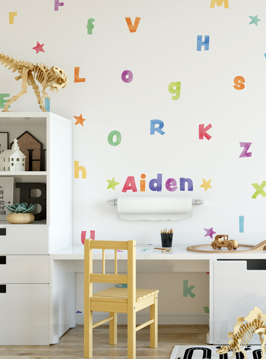Colorful watercolor alphabet wall stickers with a dinosaur skeleton, creating a whimsical and playful atmosphere in a child's room. The peel-and-stick stickers allow for easy and fast application, transforming the space in minutes. , Top Sellers,Wall Stickers,All Products,Back To School