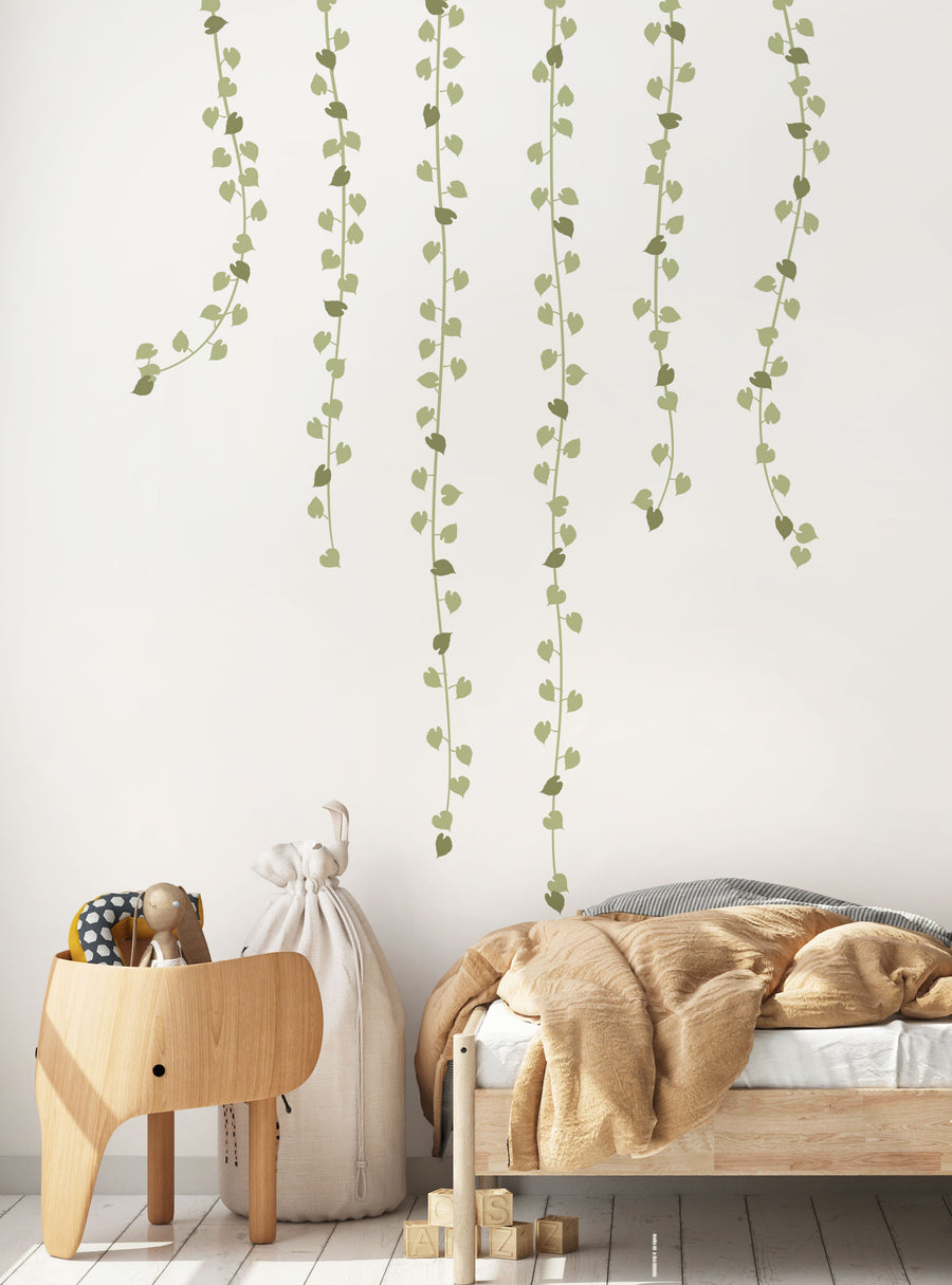 Lush and verdant hanging vine garland wall decal, featuring delicate, flowing leaves cascading down the wall, creating a natural, serene atmosphere. Perfect for adding a touch of earthy elegance to any space. , Featured Collection,Top Sellers,Wall Decals,Baby Nursery and Kids Wall Decals,All Products