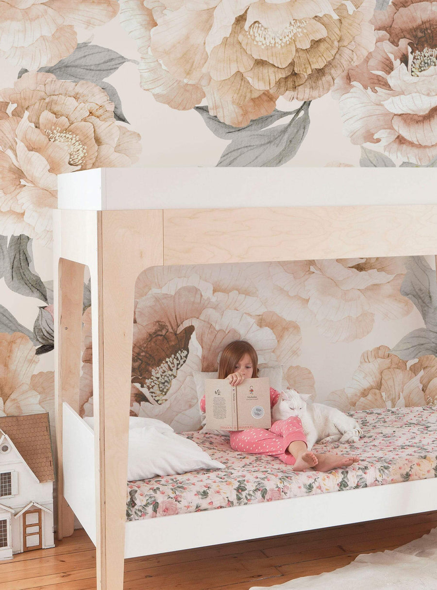Floral garden mural with soft colors and blooming peonies decorating a cozy bedroom setting, with a young girl reading a book on a comfy bed in the foreground, Top Sellers,Wall Murals,Peel and Stick Wallpaper,Floral Wallpaper,Nature Wallpaper,Kids and Baby Nursery Wallpaper,Floral Murals,Nature Murals,Kids Murals,All Products,Wallpaper and Murals, W8024-Grey-Sample-Vinyl, W8024-Grey-Sample-Fabric, W8024-Grey-Sample-Unpasted