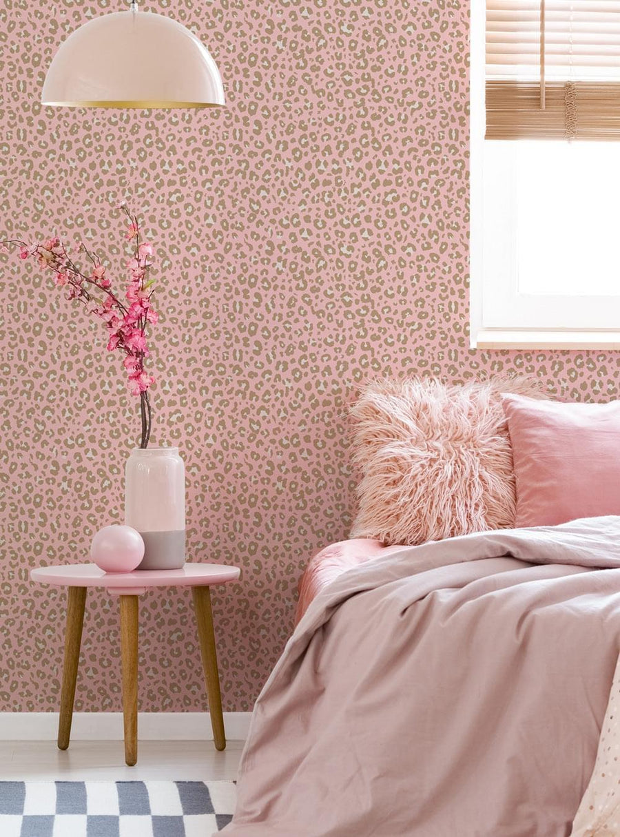 A close-up of a leopard print wallpaper, showcasing the intricate and vibrant pattern. The wallpaper features a variety of shades of pink and tan, creating a warm and cozy feel in the room. The image also shows a glimpse of a bedroom setting, with a plush pink comforter and a fuzzy throw pillow, adding to the overall stylish and trendy aesthetic. This wallpaper would be perfect for adding a touch of wild and chic flair to any space. , Top Sellers