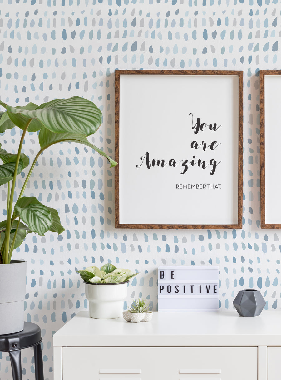 Colorful confetti-inspired peel and stick wallpaper adorns the walls, creating a cheerful and vibrant backdrop. The image conveys a sense of positivity and self-affirmation, with a framed artwork displaying the message "You are Amazing - Remember That". This modern and stylish wallpaper design is perfect for transforming any space, whether it's a kids' nursery, a home office, or a cozy living room. , Top Sellers,Peel and Stick Wallpaper,Kids and 